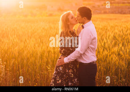 Man and woman embracing and kissing in wheat  field on the dusk,  countryside Malta Stock Photo