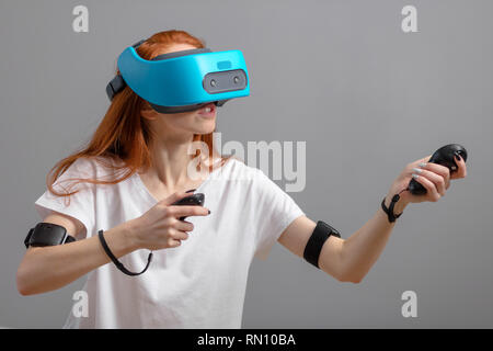 Teenage female in casual wear with VR glasses and joystick having 3D experience, virtual reality concept.