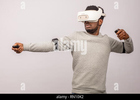Ethnic dark-skinned bearded male model in virtual reality headset playing tennis in augmented reality. Future. Future technology concept. Isolated on  Stock Photo