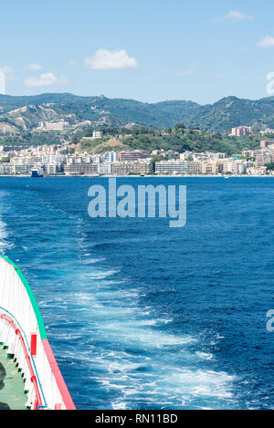 View of the sea from the stern of a car ferry across the Strait of Messina and in the background the city of Messina. Vertical view Stock Photo