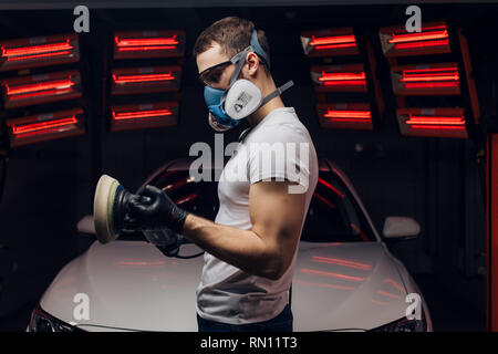 Young man preparing for polishing car in service. close up side view photo. free time, hobby Stock Photo