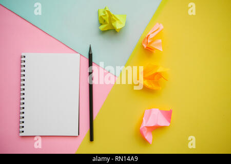 Blank notepad with place for text and a pencil on a multi-colored background. Stock Photo