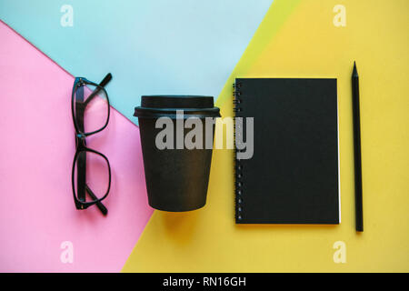 Glasses, notebook and other items on a colorful background. Stock Photo