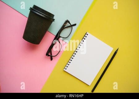 Notebook, glasses and other items on a colorful background. Stock Photo