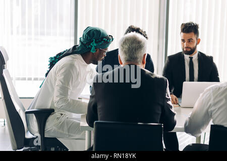 Caucasian businessman sharing ideas on project with his multi-ethnic co-workers in conference room, emotional, positive and focused on his speech man  Stock Photo