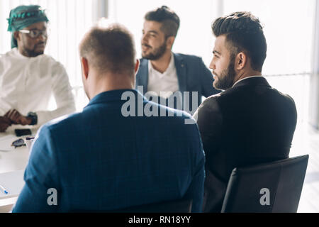 startup business, serious multiethnic business people of different age and races gather in meeting room in white modern office interior, close up view Stock Photo