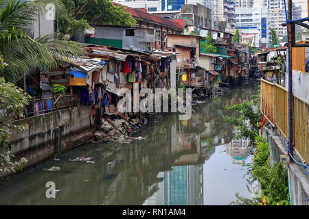 N-wards view from Soler Street bridge to the shack crowded banks of the Estero de San Lazaro channel of the Pasig river-Broadview Towers on background Stock Photo