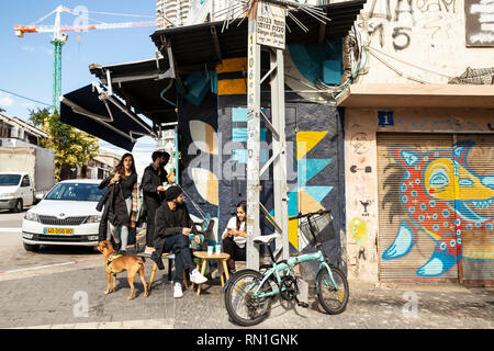 Tel Aviv-Yafo, Tel Aviv, Israel - December 28, 2018: Young Israeli people with a dog and bike, chatting and relaxing in caffe shop, Florentin district Stock Photo