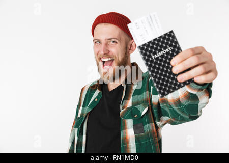 Portrait of happy guy wearing hat and plaid shirt holding passport and travel tickets while standing isolated over white background Stock Photo