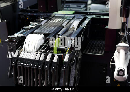 Surface mount technology component placement machine with tape and reel feeders in the foreground. Selective focus. Stock Photo