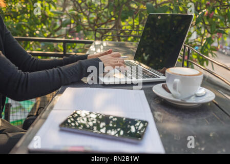 Woman hand writing notes in the sunny morning Stock Photo