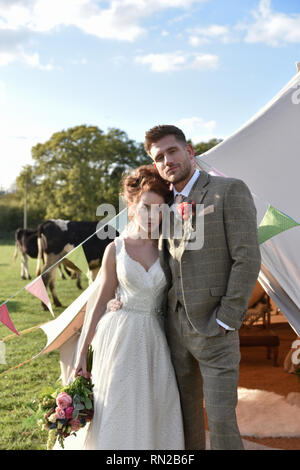 A beautiful couple get married in a romantic Farm location- she is a redhead and wers a short vintage wedding dress. He is tall and has tatoos