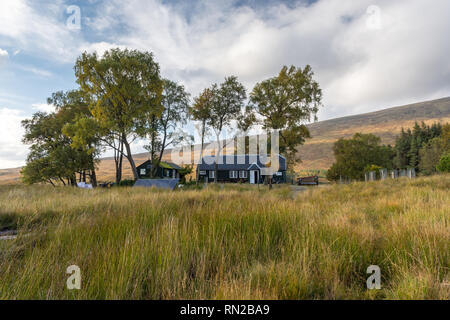 Corrour, Scotland, UK - September 25, 2017: Autumn sun shines on the simple cabins of Loch Ossian Youth Hostel in the remote Highlands of Scotland. Stock Photo