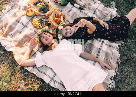 Two best friends on picnic in the field laying on the laid smiling top view Stock Photo