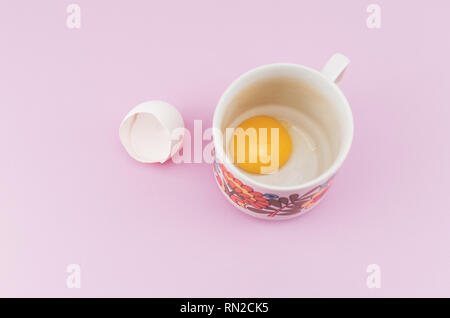 white empty broken egg shell and egg yolk in a cup Stock Photo