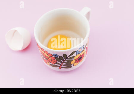 white empty broken egg shell and egg yolk in a cup Stock Photo