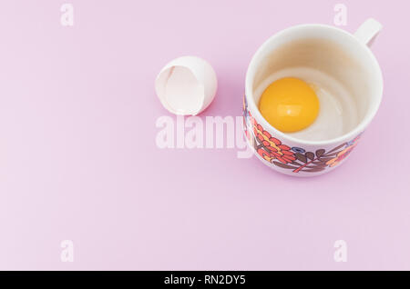 white empty broken egg shell and egg yolk in a cup Stock Photo