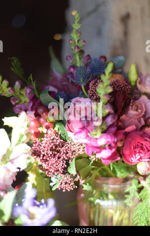 Beautiful vibrant cut flowers in a display in a strong low natural light with a rustic backdrop- they are detailed and very colourful Stock Photo