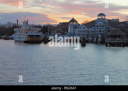 Boats, city skyline and waterfront of Alexandria, Virginia viewed from the water at sunset Stock Photo