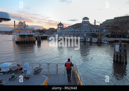 Boats, city skyline and waterfront of Alexandria, Virginia viewed from the water at sunset Stock Photo