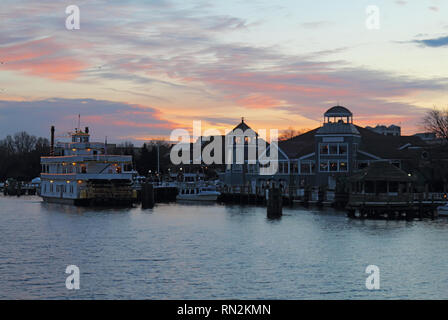 Boats, city skyline and waterfront of Alexandria, Virginia viewed from the water at sunset Stock Photo