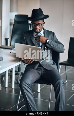 fashion dandy using the computer while sitting in the office. stylish man browsing the net . close up photo. lifestyle Stock Photo