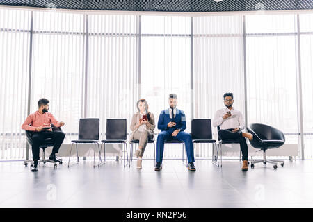executive people in fashipn suits spending time with their gadgets.waitness.