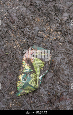 Food packaging discarded in the countryside. Plastic candy wrapper waste Stock Photo
