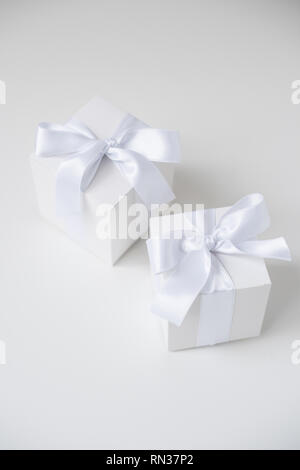 wo white square boxes with silk ribbon on white background Stock Photo