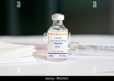 Human papilloma virus vaccine in a glass vial in a medical setting Stock Photo