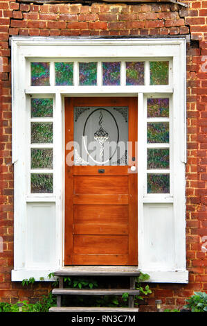 Beautiful stained glass window panes outline entry to old home in Tennessee.  Door frame is white as is door knob. Stock Photo