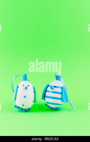 two blue various decorative eggsin the form of chicken  laid out on a green background, holiday background, copy space Stock Photo