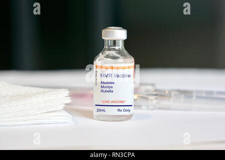 MMR Vaccine for measles, mumps, and rubella in a glass vial in a medical setting Stock Photo