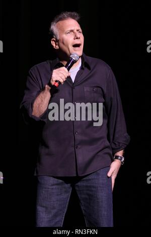 Comedian, actor, television personality, author and musician Paul Reiser is shown entertaining a sold out crowd during a 'live' comedy show. Stock Photo