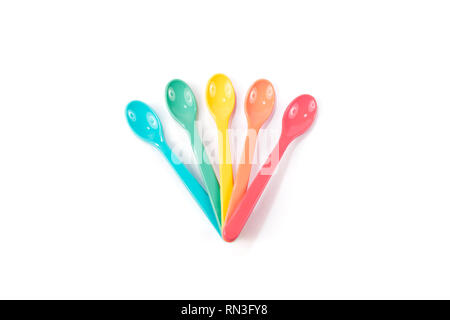 Colorful bunch of plastic baby spoons on white background - happy food Stock Photo