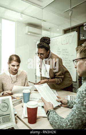 Two students listening to their teacher attentively during the class Stock Photo