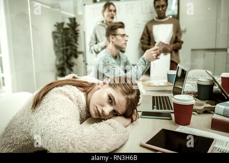 Dark-eyed student feeling exhausted and bored during the class Stock Photo
