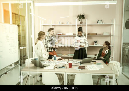 Four freelancers using thinking hats for discussing new project Stock Photo