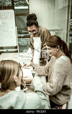 Two students and teacher feeling positive while studying Stock Photo