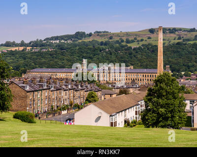 Bradford, England, UK - July 1, 2015: Sun shines on the industrial revolution-era Salt's Mill factory building and traditional worker's houses of Salt Stock Photo