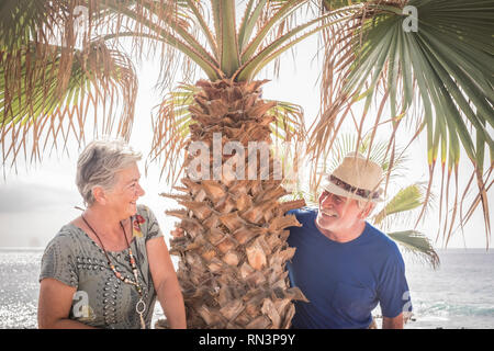 Happy senior couple laughing hugged on a summer day. concept of vacation, relaxation, rest. Behind it as a sea, ocean background - Cheerful caucasian  Stock Photo