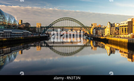 Newcastle, England, UK - February 5, 2019: Dawn light illuminates the Sage Gateshead, iconic Tyne Bridges and Newcastle Quayside on the River Tyne. Stock Photo