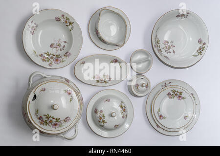 Set of vintage ceramic factorycrafted tableware with flowers of subtle colors on white background, 11 pieces, top view Stock Photo