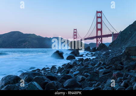 View of the Golden Gate Bridge from Marshall Beach at early dawn at king tide, San Francisco, California, USA Stock Photo