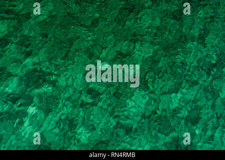 Green abstract texture background of emerald green sea water. Top view of green sea water with unique pattern. Green background. Sea water wave surfac