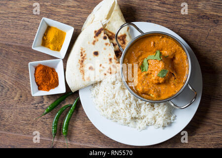 Popular Indian dish of Chicken tikka masala with boiled rice and naan breads, Stock Photo