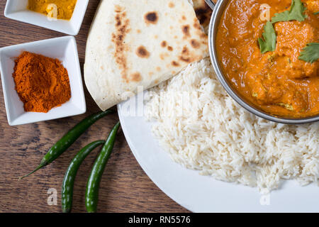 Popular Indian dish of Chicken tikka masala with boiled rice and naan breads, Stock Photo