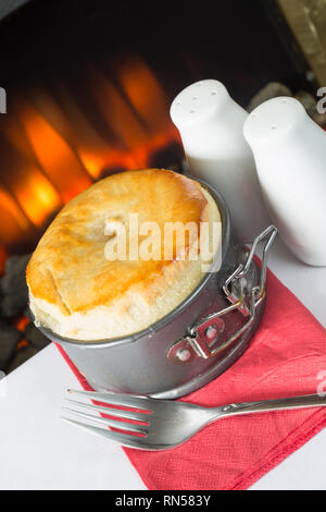 Homemade meat pie in an expanding pie tin fresh from the oven. Stock Photo