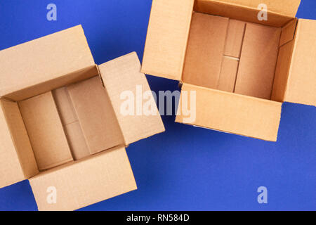 Two empty open cardboard boxes on blue background Stock Photo