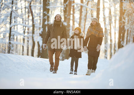 Happy Family Enjoying Walk in Winter Forest